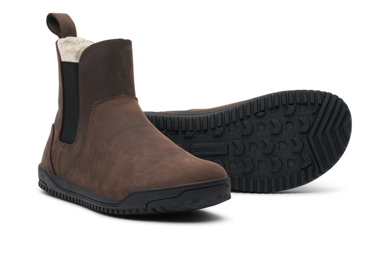 Xero Shoes Ridgeway Chelsea Lined Men Shoe in Brown. One Shoe Faces Forward Toward the Bottom Right, While the Other Shoe Sits Behind it, Flipped to Showcase its Black Textured Rubber Outsole and with Toe Facing Right.