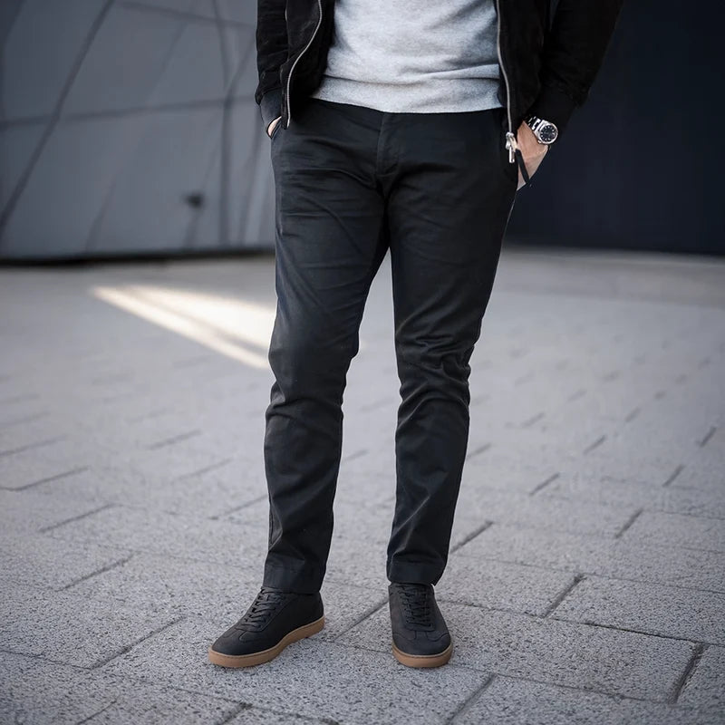 model wearing atlas midnight with dark pants, suede jacket, and gray sweater