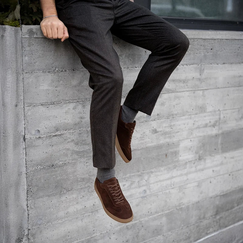 model wearing Atlas Walnut brown suede shoes with dark dress pants