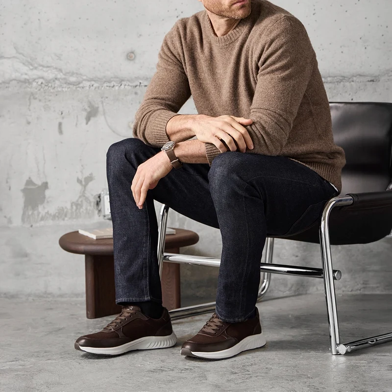 Model wearing The Axis in Walnut Suede by Amberjack with dark jeans and brown sweater