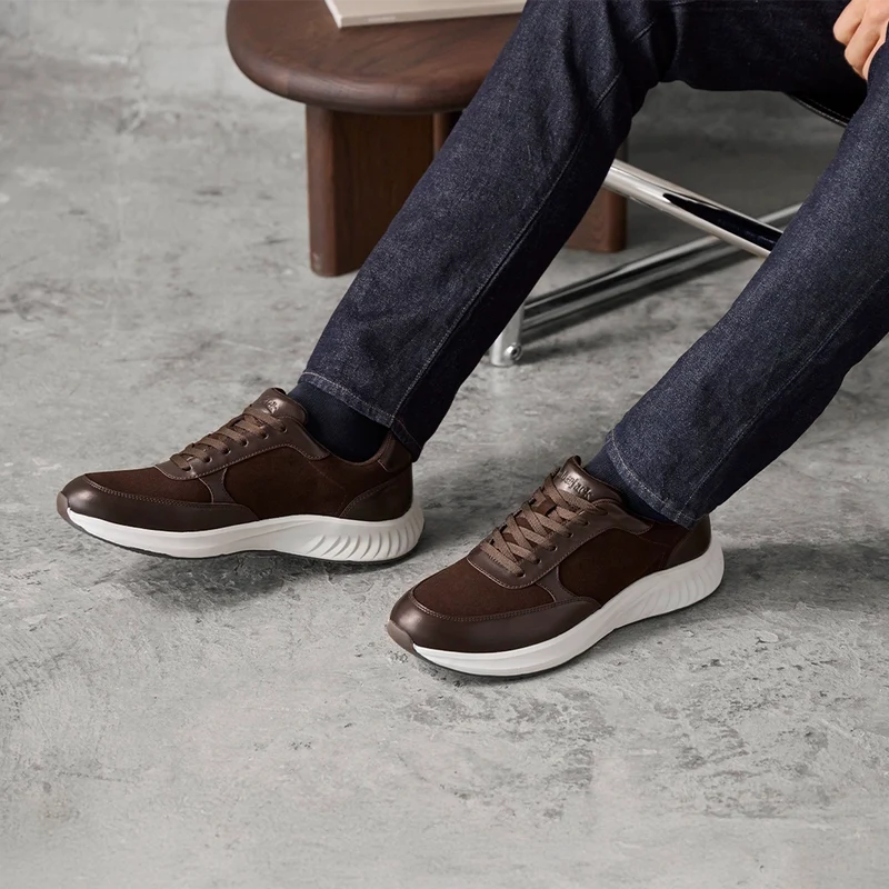 Model wearing The Axis in Walnut Suede by Amberjack with dark jeans and brown sweater