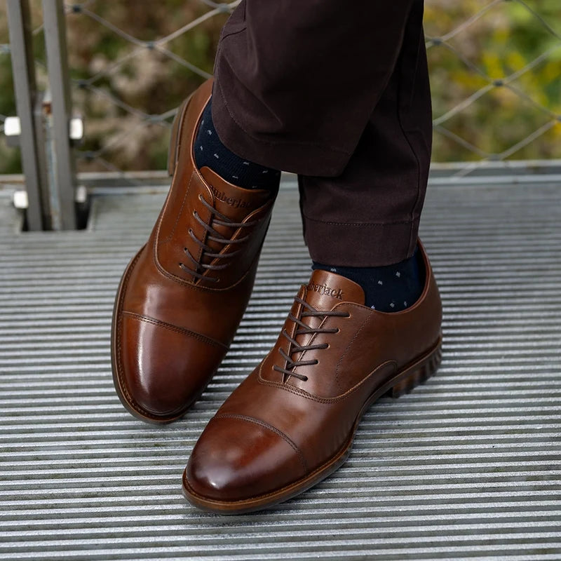 The Regent Chestnut on model with blue dress socks and dark brown chinos