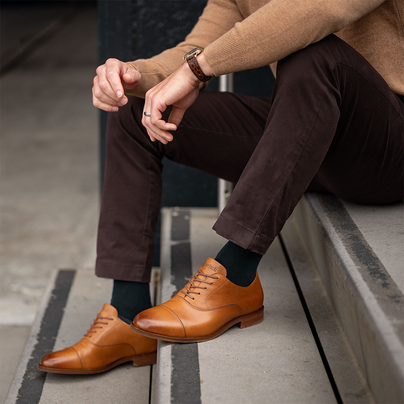 Close up of a man wearing honey dress shoes.